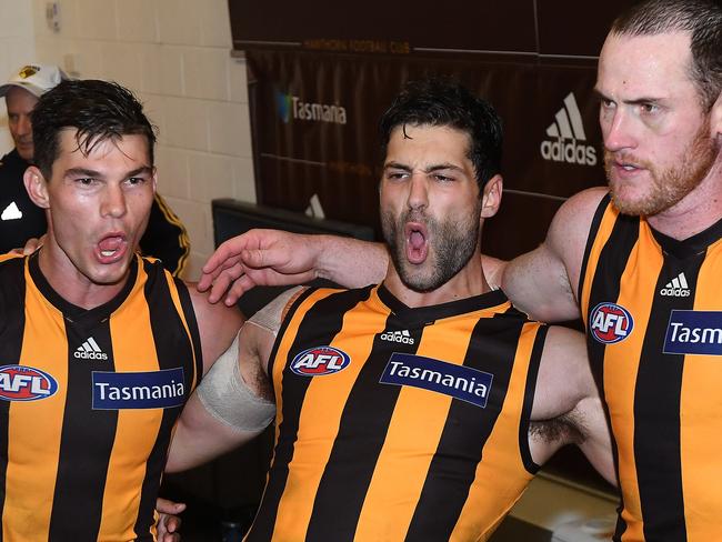 David Mirra (middle) sings the Hawthorn song with Jaeger O’Meara and Jarryd Roughead.