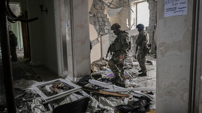 Ukrainian servicemen walk inside the destroyed regional headquarters of Kharkiv on March 27, 2022. Picture: AFP