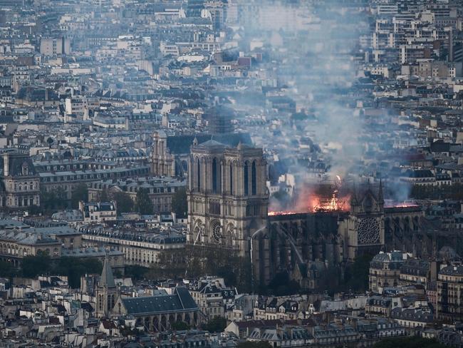 Smoke and flames rise during a fire at the landmark Notre-Dame Cathedral in central Paris on April 15, 2019, potentially involving renovation works being carried out at the site, the fire service said. - A major fire broke out at the landmark Notre-Dame Cathedral in central Paris sending flames and huge clouds of grey smoke billowing into the sky, the fire service said. The flames and smoke plumed from the spire and roof of the gothic cathedral, visited by millions of people a year, where renovations are currently underway. (Photo by Philippe LOPEZ / AFP)