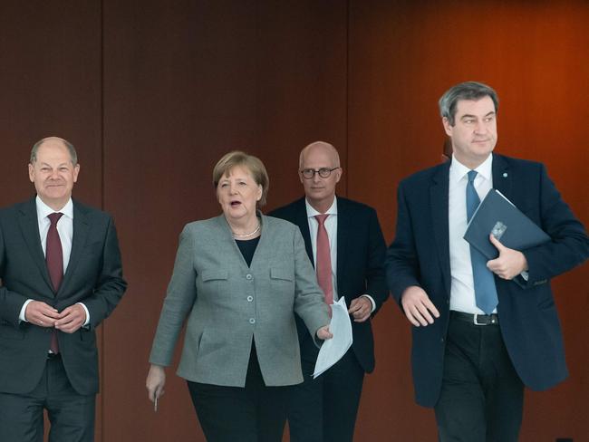 Angela Merkel with Peter Tschentscher, Mayor of Hamburg and German Finance Minister and Vice-Chancellor Olaf Scholz. Picture: AFP.