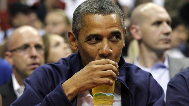 Barack Obama sips beer at basketball game in Washington. Picture: AP