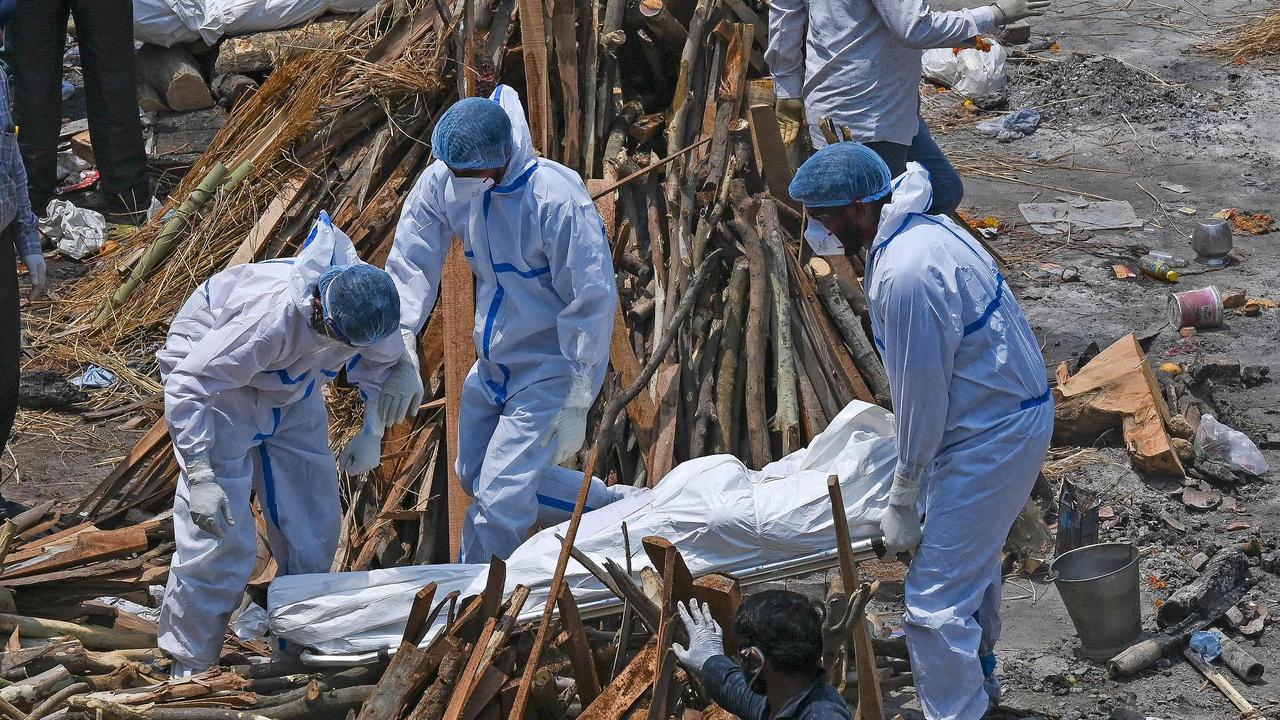 Family members and ambulance workers wearing personal protection equipment at a cremation ground in New Delhi on April 27. Picture: Prakash Singh/AFP