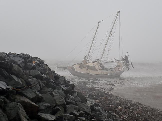 A ship has been thrown upon rocks near the Airlie Beach Marina during Cyclone Debbie. Picture: Alix Sweeney