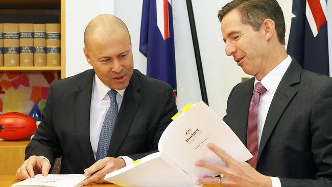 Treasurer Josh Frydenberg and Finance Minister Simon Birmingham look at copies of the federal budget for 2022/23 at Parliament House in Canberra on Tuesday. Picture: AFP