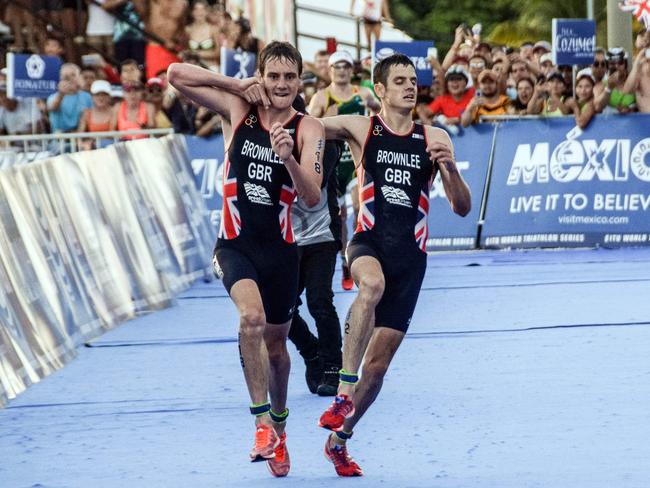 British athlete Alistair Brownlee (left) helps his brother Jonathan before crossing the line in second and third place during the ITU World Triathlon Championships in Cozumel, Quintana Roo, Mexico.