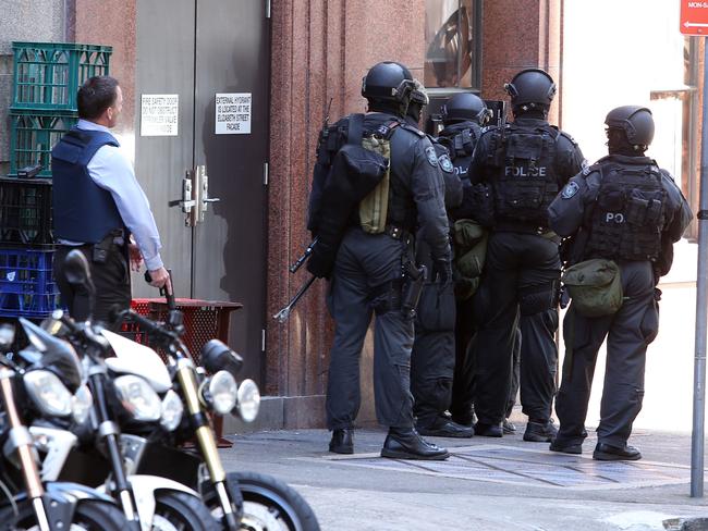 Officers wait outside the cafe earlier in the day.