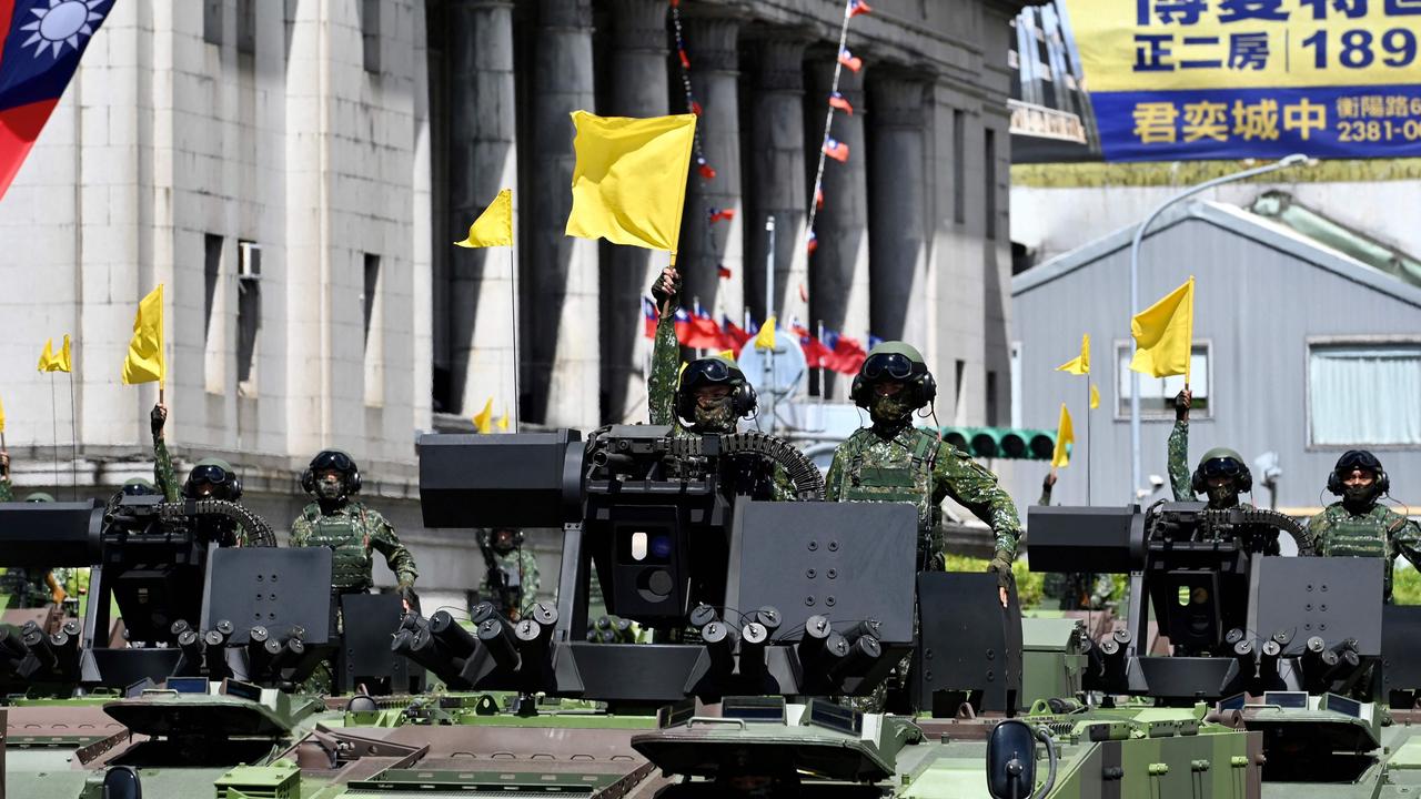 Taiwanese soldiers raise flags on military vehicles during a national day parade in front of the Presidential Palace in Taipei in early October. Picture: AFP