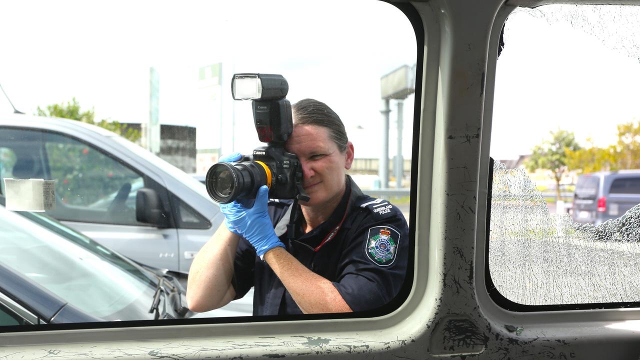 Senior Constable Korinne Lardner from the Cairns Police scenes of crime forensic team investigates damage to two vehicles parked at the Cairns Taxis base in Portsmith. Picture: Peter Carruthers