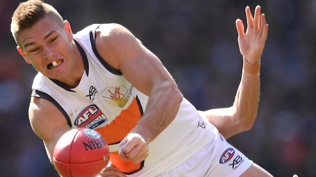 Adam Tomlinson shoots out a handball during the grand final, his last game for the Giants. Picture: Quinn Rooney/Getty Images.