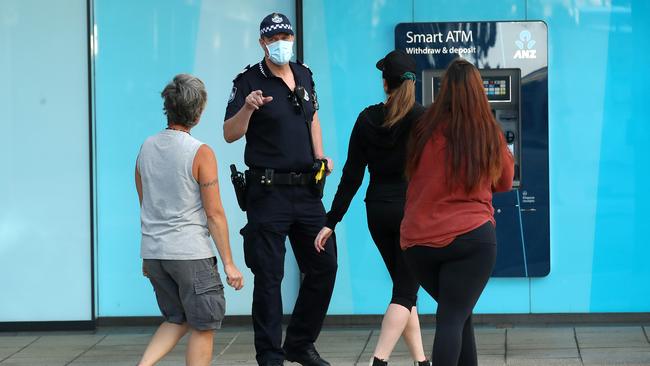 Police question pedestrians as they patrol the CBD during lockdown in Brisbane. Picture: NCA NewsWire / Jono Searle