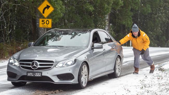 The snowy weather at Mt Macedon Locals helping cars having trouble getting up the slippery road. Picture: Jay Town