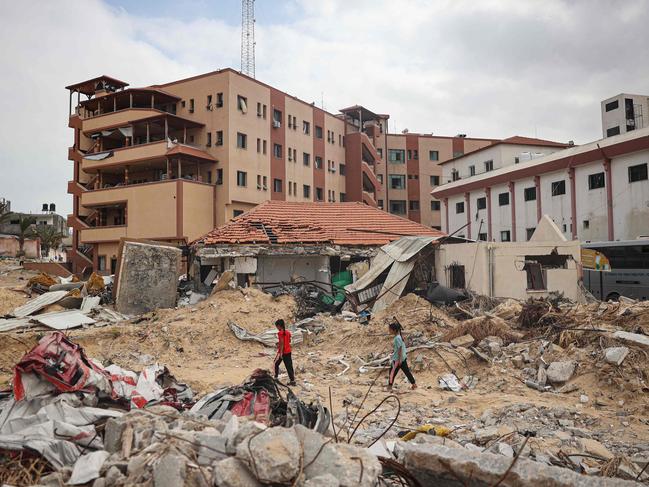 Palestinians walk on a ravaged road in front of Nasser Hospital in Khan Yunis in the southern Gaza Strip. Picture: AFP