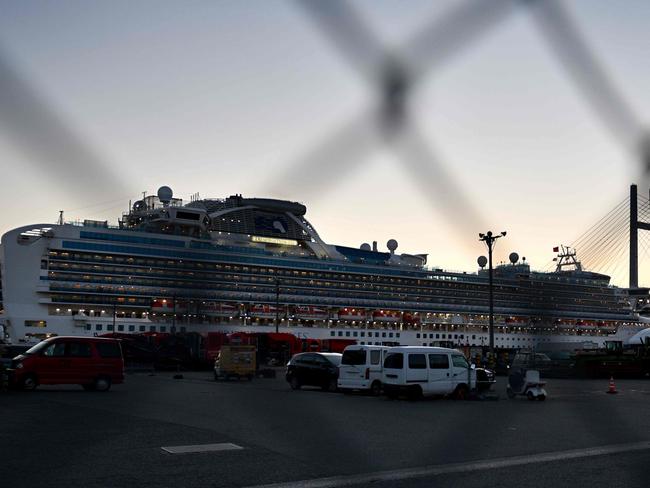 The Diamond Princess cruise ship, with over 3700 people quarantined on-board due to fears of the new coronavirus, is seen through a fence while anchored at the Daikoku Pier Cruise Terminal in Yokohama port. Picture: AFP