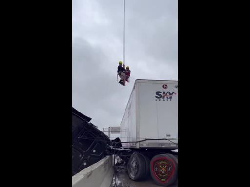Driver Hoisted to Safety After Crash Leaves Truck Dangling from Overpass