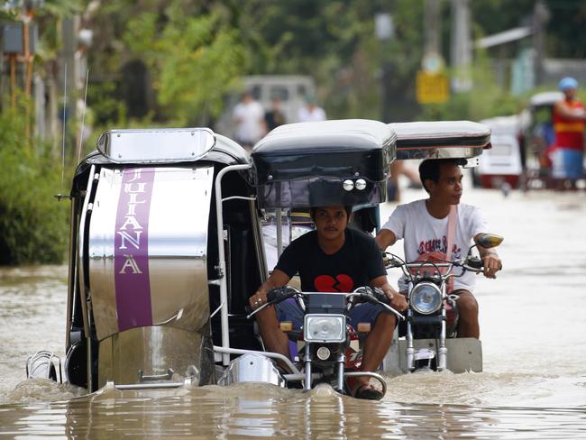 People travel through a flooded road. Picture: AP