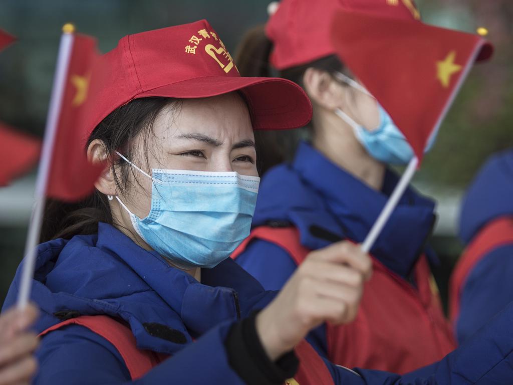 WUHAN, CHINA - MARCH 17:  (CHINA OUT) The volunteers wave the Chinese national flag to send of the China national emergency medical team at the Tianhe airport on March 17, 2020 in Wuhan.Hubei,China.The first batch of medical assistance teams started leaving Hubei Province early on Tuesday as the epidemic outbreak in the hard-hit province has been subdued. The 3,675 medical staffers belonging to 41 medical teams from across China have assisted 14 temporary hospitals and seven designated hospitals in Wuhan, the provincial capital and epicenter of the outbreak.  (Photo by Stringer/Getty Images)