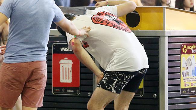 A quick thinking drunk schoolie (circa 2015) has tried to have a chunder into a bin... and missed. A rare sight during 2022 schoolies. Picture: Marc Robertson