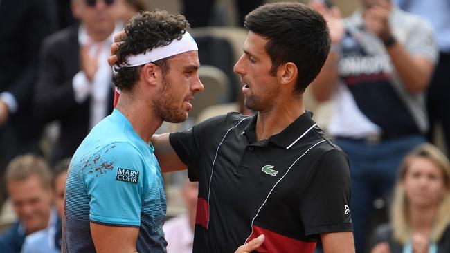 TOPSHOT - Italy's Marco Cecchinato (L) embraces as he celebrates after victory over Serbia's Novak Djokovic in their men's singles quarter-final match on day ten of The Roland Garros 2018 French Open tennis tournament in Paris on June 5, 2018. World number 72 Marco Cecchinato became the first Italian man in 40 years to reach a Grand Slam semi-final with a breathtaking 6-3, 7-6 (7/4), 1-6, 7-6 (13/11) epic victory over 12-time major winner Novak Djokovic.   / AFP PHOTO / Eric FEFERBERG