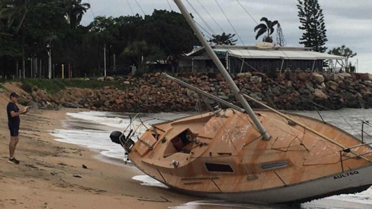 A local checks out a boat washed up on The Strand in Townsville after TC Kirrilly hit. Photo: Evan Morgan