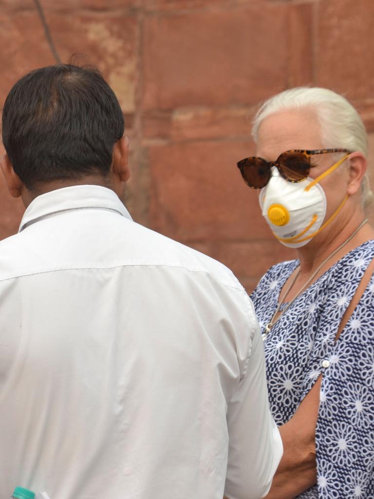 Foreign tourists wear face masks as they visit the Taj Mahal under heavy smog conditions. Picture: Jewel Samad / AFP