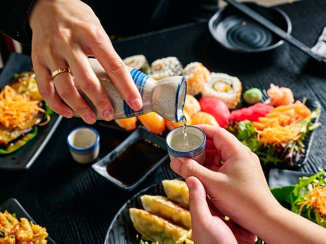 Guests enjoying sake with freshly made dishes.