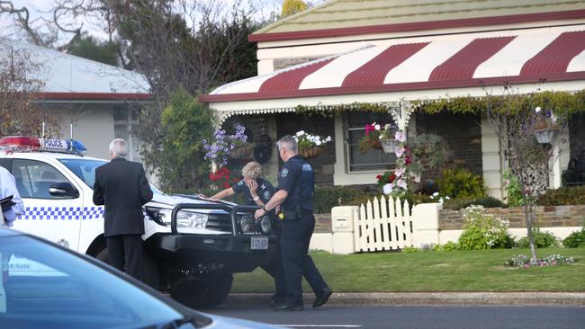 Police outside the home in Millicent where the bodies of a woman and her elderly mother was found.