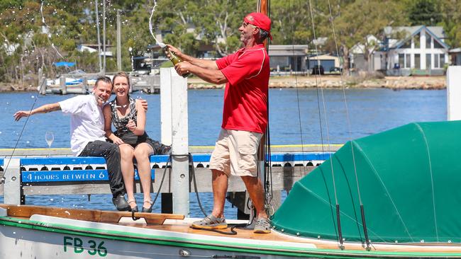 Owners and chef of Sardine Paynesville Eatery Bar Mark and Victoria Briggs hanging out with Peter Medling on his 1936 Gippsland Lakes Fishing Boat. Picture: Alex Coppel