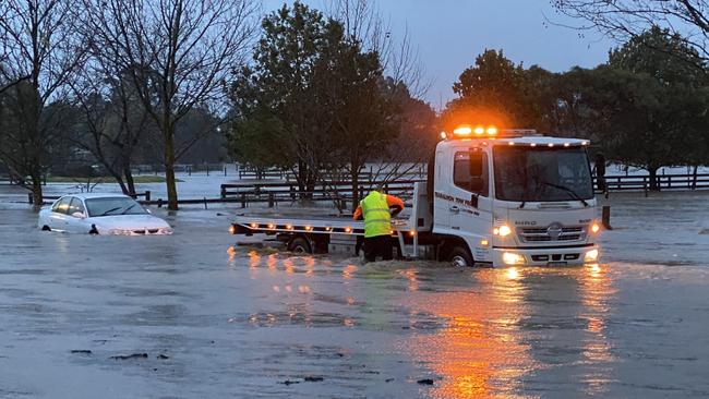 A car is towed out of rising floodwaters near Traralgon. Picture: Jenni Rohde