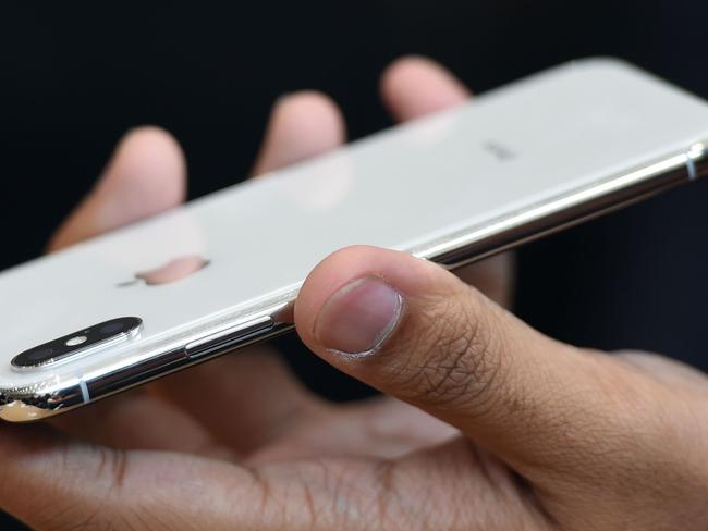 People try out the new iPhone X during a media event at Apple's new headquarters in Cupertino, California on September 12, 2017.  / AFP PHOTO / Josh Edelson