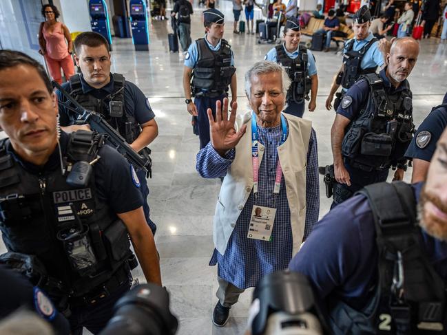 TOPSHOT - Bangladesh's finance pioneer Muhammad Yunus (C) is escorted by French police personnel as he arrives at Roissy-Charles de Gaulle Airport, north of Paris on August 7, 2024, enroute to Bangladesh, where he is set to lead a caretaker government after mass protests ousted premier Sheikh Hasina. Nobel-winner Muhammad Yunus will lead Bangladesh through a "democratic process" when he arrives in the country to helm an interim government, army chief Waker-Uz-Zaman said. (Photo by Luis TATO / AFP)