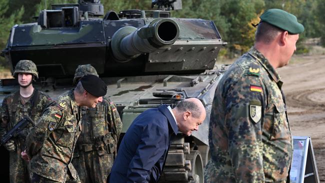 German Chancellor Olaf Scholz walks under the cannon of a Leopard 2 main battle tank of the Bundeswehr. Picture: Getty Images