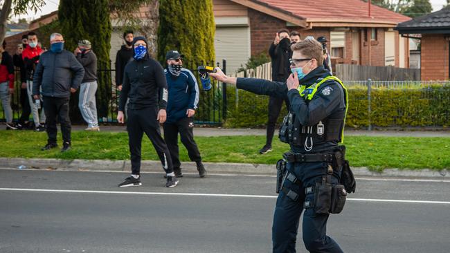 An officer points pepper spray at protesters in Dandenong. Picture: Jason Edwards