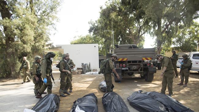 Israeli soldiers remove the bodies of civilian. Picture: Getty Images