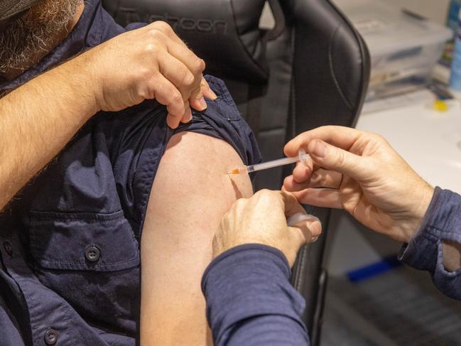 MELBOURNE, AUSTRALIA - JULY 11: A pharmacist administers the injection of a Covid-19 vaccination booster-shot to a customer at Exhibition Pharmacy on July 11, 2022 in Melbourne, Australia. More Australians are now eligible to receive a fourth dose of a COVID-19 vaccine, after the Australian Technical Advisory Group on Immunisation (ATAGI) approved people aged 30 and above can access additional booster shots from Monday 11 July. While over 30s are now eligible for an additional dose if they choose, health authorities are strongly urging people over 50 to get the fourth COVID-19 vaccine booster and for people to wear masks indoors in public as coronavirus infections continue driven by Omicron subvariants. (Photo by Asanka Ratnayake/Getty Images)