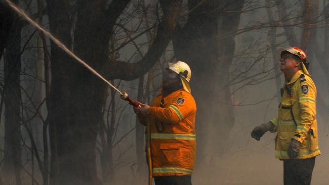 Crews protecting houses along Lemon Tree Passage Rd, in Salt Ash, on Friday morning. Picture: AAP