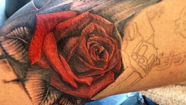 A close up of the rose tattoo with further designs including the hand gun and the dollar signs pencilled in ready for tattooing.