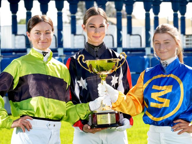 Top SA jockeys (LtoR) Teagan Voorham,Taylor Johnstone, and Rochelle Milnes, in their Adelaide Cup jockey silks with the Adelaide Cup. All superstitious so very reluctant to hold the cup, and only reluctantly held it when they each had a hand on it. 7 March 2025. Picture: Dean Martin