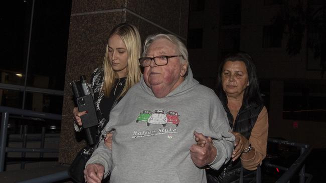 Former swim coach Dick Caine is escorted out of Bankstown police station with wife Jenny and lawyer Sophie Newham after receiving bail. Picture: Liam Mendes / The Australian