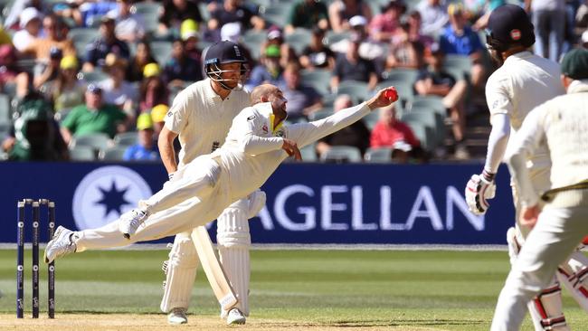 Nathan Lyon dives to pouch a screamer off his opposite number Moeen Ali, who went for 25, during day three of the second Ashes Test in Adelaide. Picture: AFP