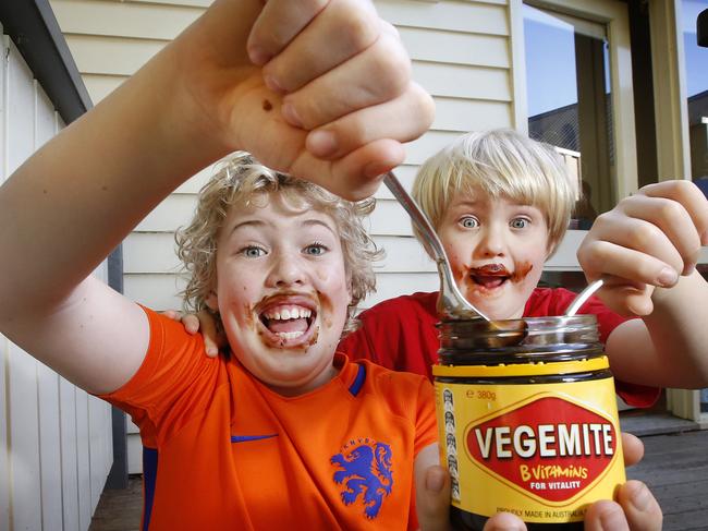 Brothers Max 11 and Alex 6 enjoying their Vegemite by the spoonful while at home. Picture: David Caird