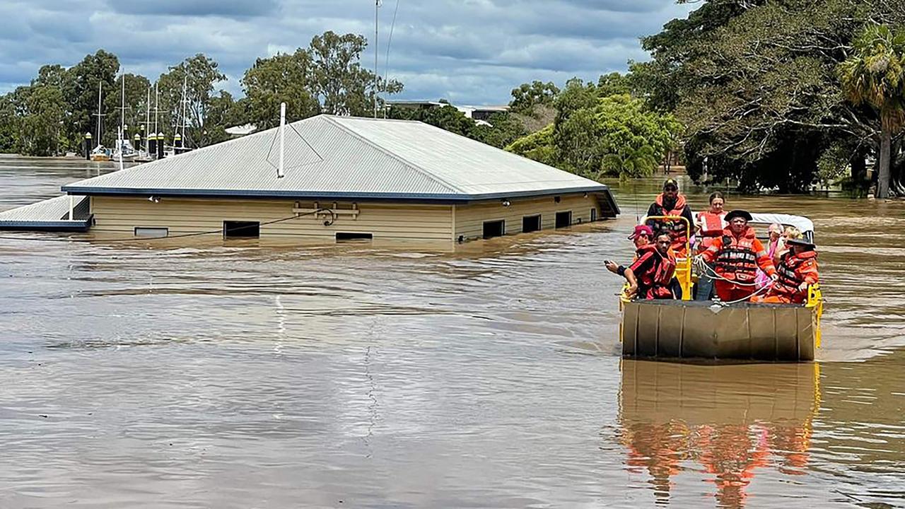 This handout photo taken on February 28, 2022 and received on March 1 from the Queensland Fire and Emergency Services (QFES) shows rescuers on a boat evacuating people along a flood street around Maryborough in Queensland