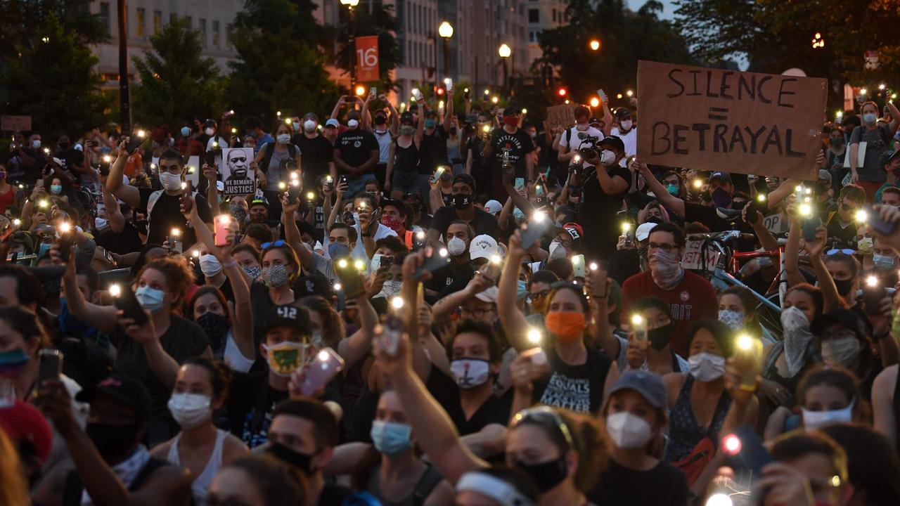 Protesters hold up their phones during a demonstration over the death of George Floyd outside the White House. Picture: Eric Baradat/AFP