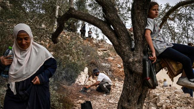 A Palestinian man lights a fire to cook for his family during the olive harvest at a grove outside Ramallah in the occupied West Bank. Picture: AFP