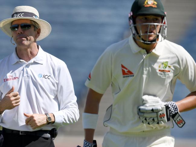 Onfield umpire Nigel Llong of England (L) looks on as Australia's Matthew Renshaw holds his stomach while running back to the pavilion during the first day of the first cricket Test match between India and Australia at The Maharashtra Cricket Association Stadium in Pune on February 23, 2017. ----IMAGE RESTRICTED TO EDITORIAL USE - STRICTLY NO COMMERCIAL USE----- / GETTYOUT / AFP PHOTO / INDRANIL MUKHERJEE / ----IMAGE RESTRICTED TO EDITORIAL USE - STRICTLY NO COMMERCIAL USE----- / GETTYOUT