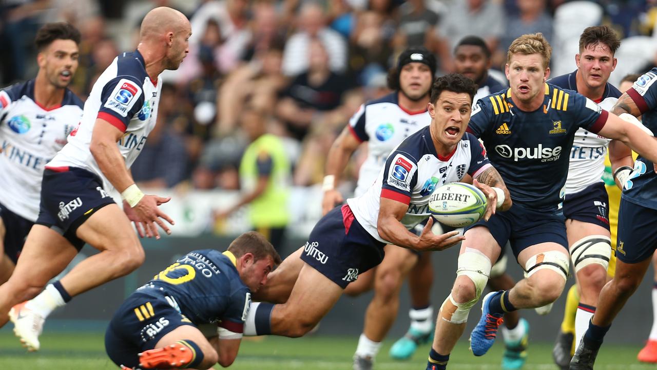 Matt To’omua of the Rebels offloads in contact against the Highlanders in Dunedin.