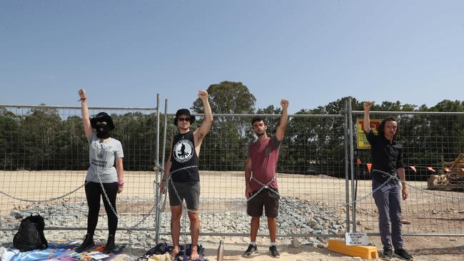 Black Swan Lake protest at Bundall goes to another level, with protesters chaining themselves to the fence and then getting themselves arrested after running onto the worksite and stopping the trucks. Protesters chained to the fence. Picture Glenn Hampson