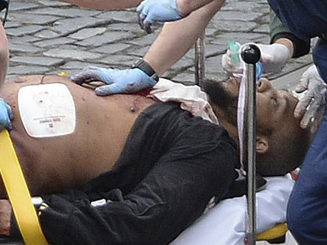 Khalid Masood is treated by emergency services outside the Houses of Parliament. Picture: AP