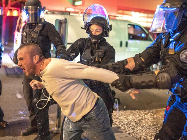 US police hold back a man who was with the victim of a fatal shooting as counter-protesters and pro-Trump supporters clashed in Portland. Picture:/Getty Images/AFP