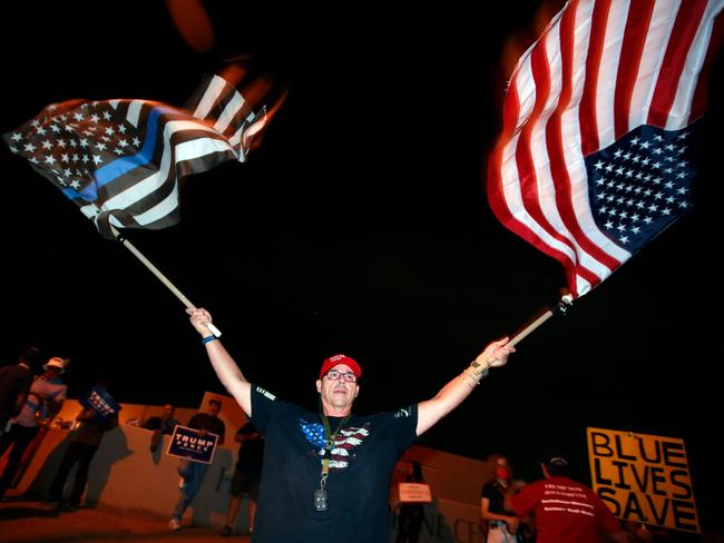 Trump supporter Raul Latorre waves flags and joins others in protesting the Nevada vote outside Clark County Election Department in North Las Vegas. Picture: AFP