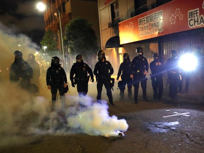 Police officers stand behind a canister of tear gas during a protest in Oakland, California. Picture: Getty